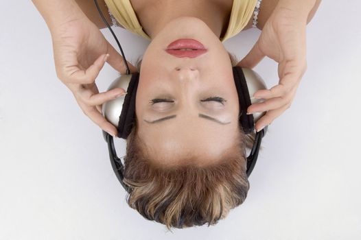 laying woman with headphone against white background