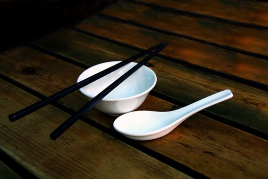 White daily Chinese soup bowl with chop sitcks on wooden table