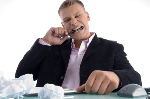 frustrated man biting on pen with teeth  against white background