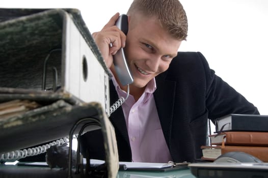 handsome smiling manager busy on phone on an isolated white background