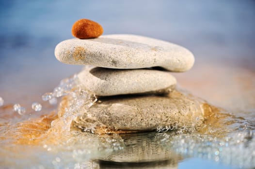 The pile of stones is reflected in a sea wave in the summer