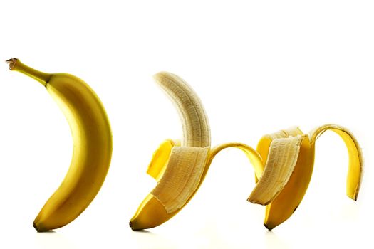 three bananas some peeled on white background