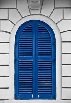 A blue louvered window on an old house in Malta