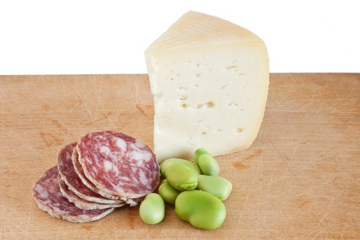 cutting board with salami pecorino and broad beans isolated on white background with clipping path