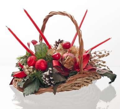 Christmas decorative basket isolated on white standing on a reflective surface.