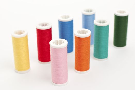 Colorful Spools of sewing thread isolated on white background.