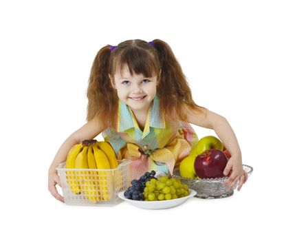 A little girl with a big bunch of fruit on white