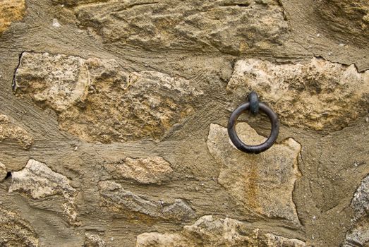 a old stone wall with a ring mounted on it