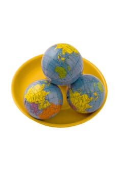 Three models of globes on the yellow plate and isolated on the white