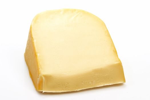 A big chunk of gouda cheese on bright background