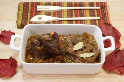 Cooked marinated beef meat in a bowl with wooden spoon.