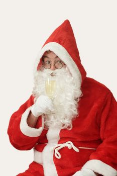 Male caucasian model of santa claus drinking a glass of champaigne - isolated on white background
