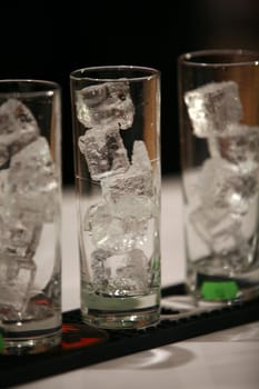 Three coctail glasses with ice cubes