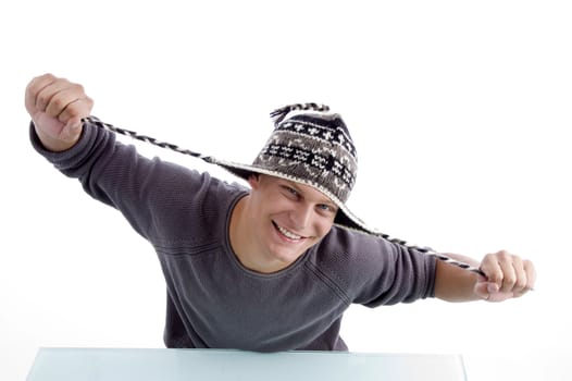 smiling male stretching his cap against white background