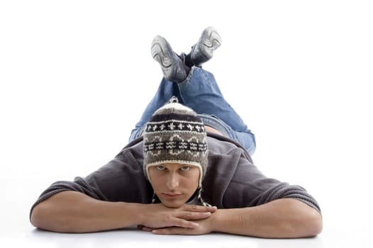 laying young man wearing winter cap on an isolated white background