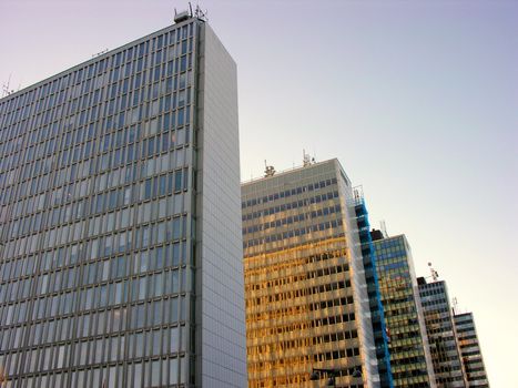 Five skyscrapers in row on soft blue sky