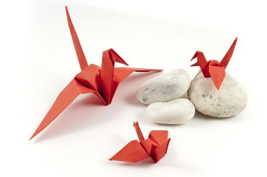 Red Origami Crane and his childres on white stones