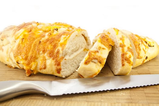 Cheese and Onion Bread on a wooden cutting board with a Knife