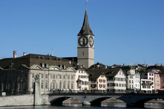 Zurich cityscape. St. Peter's Church tower with world's largest church clock face. Swiss city. Limmat river connecting with Lake Zurich.