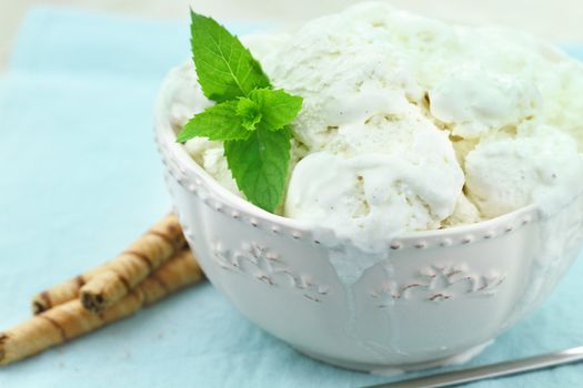 Vanilla ice cream with a sprig of fresh mint and chocolate pirouettes.