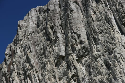 Canadian Rocky Mountains - mountain wall stone background with a piece of sky