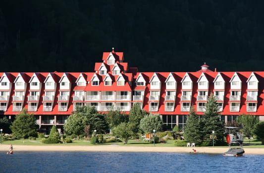 Beautiful hotel with red roof on the lakeside. Holiday resort. Three Valley Lake Chateau.