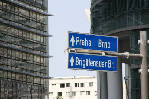 Vienna financial district downtown. Direction signs to Prague and Brno with skyscrapers in background.