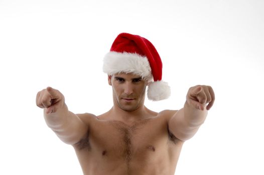 cool muscular man wearing christmas hat and pointing towards with white background