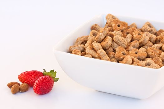 Bowl of cereal, strawberries and almonds over white