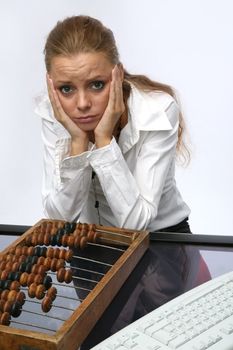 A sad girl with a keyboard and abacus, on the table