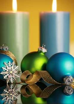 Christmas decorations on yellow background,focus on blue ball and gold ribbon