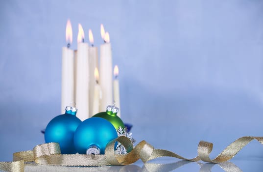 Christmas decoration on soft blue cloth, focus on blue ball and gold ribbon