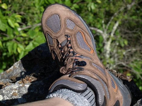 One foot hanging on the edge of mountain side as the person climbs down.