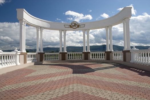 Arch with white columns on a background of the dark blue sky.