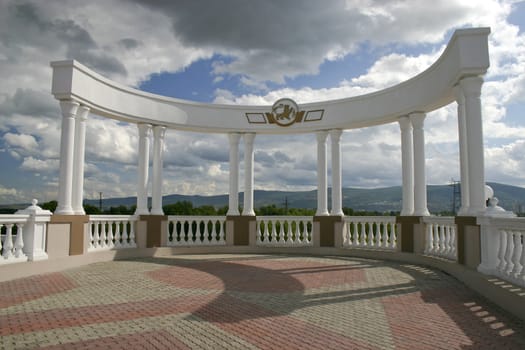 Arch with white columns on a background of the dark blue sky.