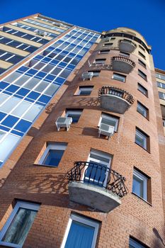 Modern building from a brick. Glass balconies.