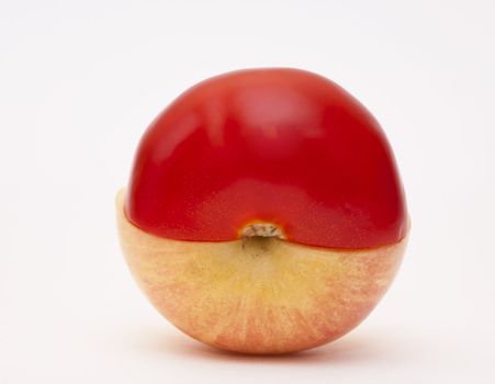 Apple and tomato halves on white background