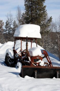 snow-covered old tractor