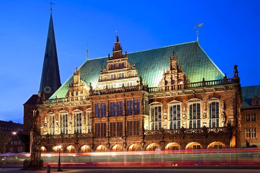 Townhall in Bremen at the blue hour. In the foreground a tram passing by. Long exposure - motion blur.