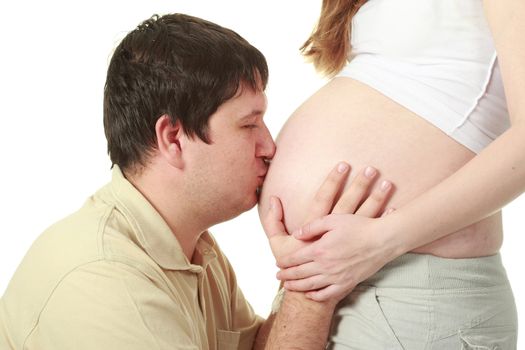 Beautiful moment between expecting parents: man kissing belly of his wife