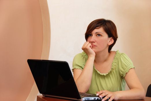 young woman in casual cloth at the office desk with notebook thinking