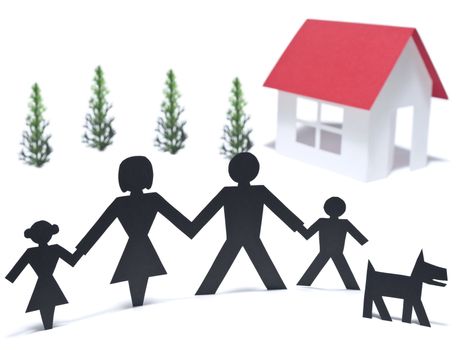 A paper family is holding hands beside their new paper house.