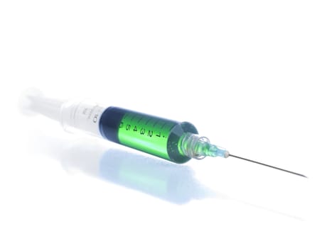 Close up on a syringe filled in with a green liquid.