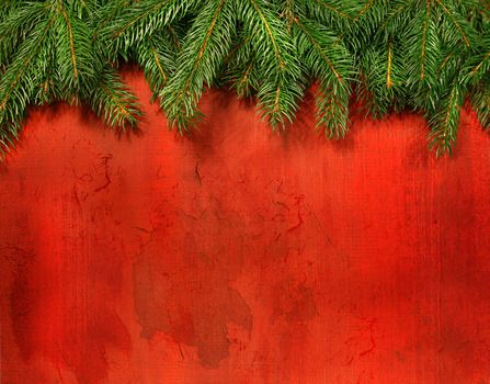 Branches of pine against rustic red wood background