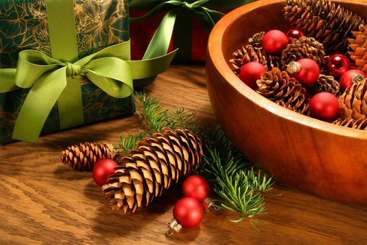 Pine cones , christmas balls and gifts on oak table