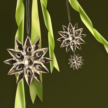 Crystal snowflakes with green ribbons on dark background