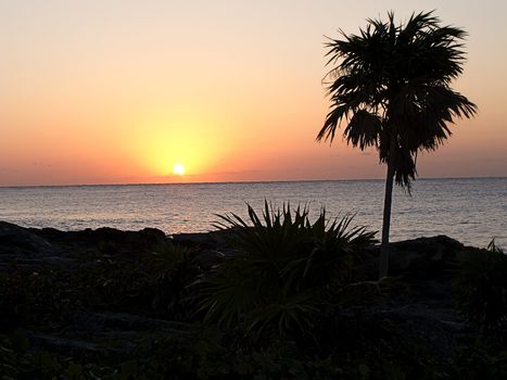 Sunrise over the caribbean sea with volcanic beach as foreground