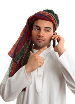 A middle eastern businessman talks on a mobile cell phone.  White Background.