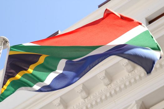 South African Flag blowing in the wind in front of the parliamentary building