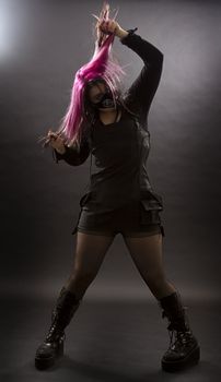 maniacal looking goth girl with pink hair and body piercing pulling her hair